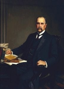 Painting of mustached man in suit at desk with papers and books