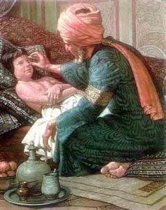 Man in turban treating eye of young boy