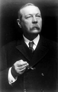 Man with mustache and holding glasses looking up and to the right