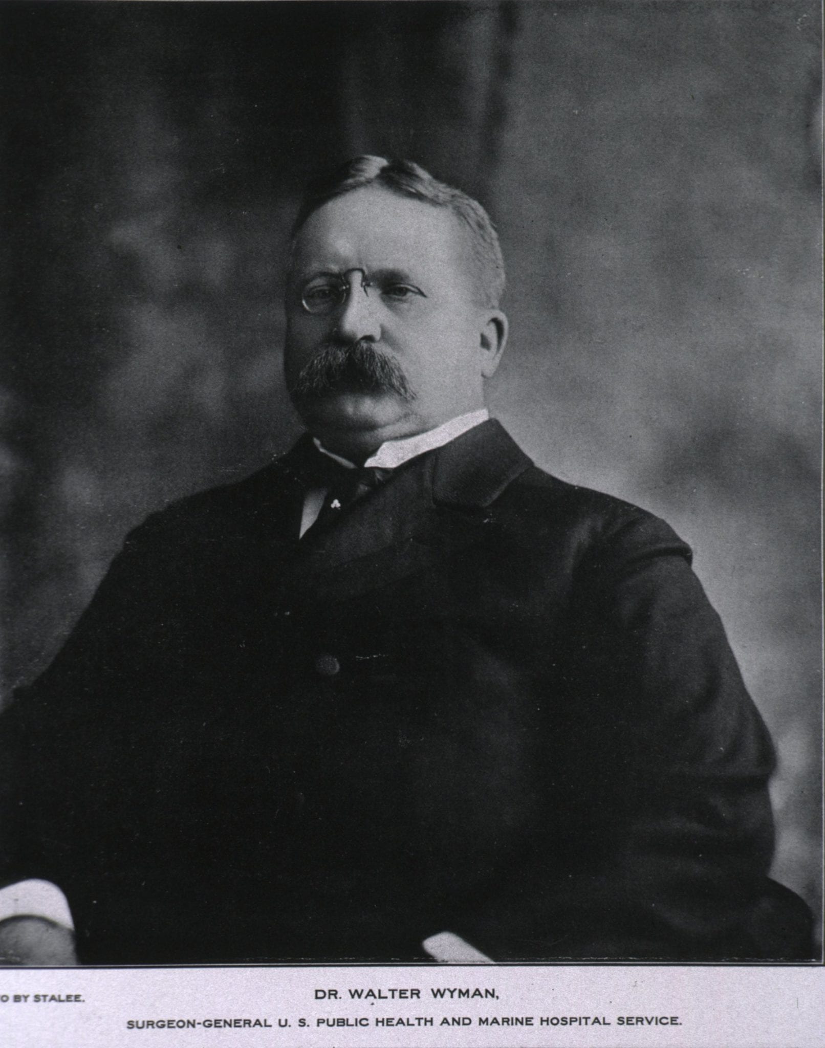 Surgeon General William Wyman, a man with glasses and a mustache, who resembles Theodore Roosevelt and who ordered investigations into the cause of yellow fever
