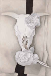 A white cow skill with white roses on a white background. A black stripe runs down near the center of the background behind the cow skull.