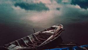 Rowboat facing out toward dark lake with clouds