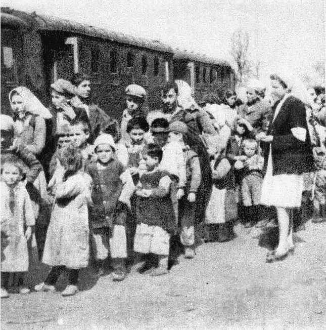Greek children with a nurse lined up by a train