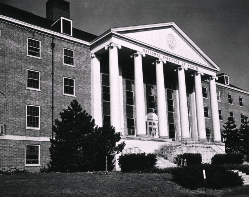 Photo of brick building with Ionic Greek columns at entrance for article on history of NIH grants