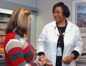 Empathetic female black doctor talking to female white patient