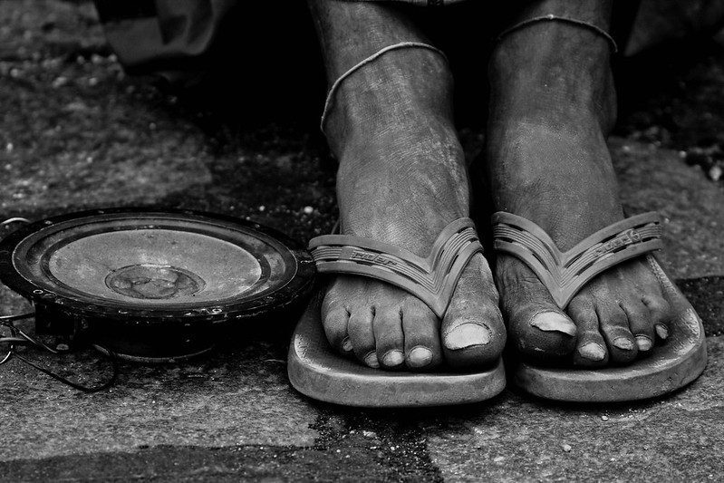 Worn feet in sandals next to a bowl